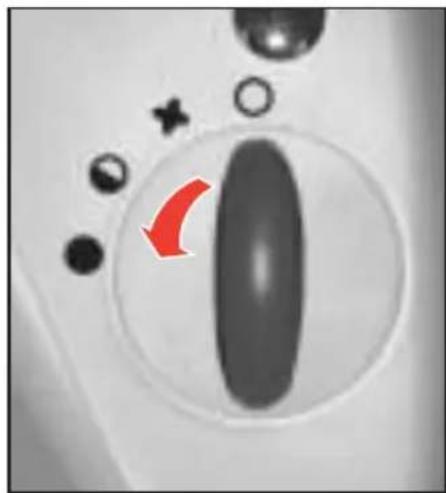 Close-up of a control panel with a red arrow pointing to a black oval object, surrounded by small icons (no text or symbols)