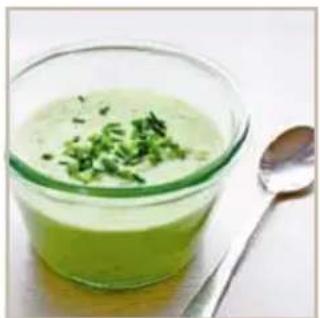 Bowl of green creamy soup with chopped green herbs, accompanied by a spoon (no text or symbols visible)