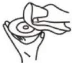 Line drawing of hands cleaning a circular object with a cloth (no text or symbols).
