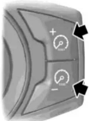 Close-up of a car dashboard control panel with speedometer icons and directional arrows indicating navigation or movement.