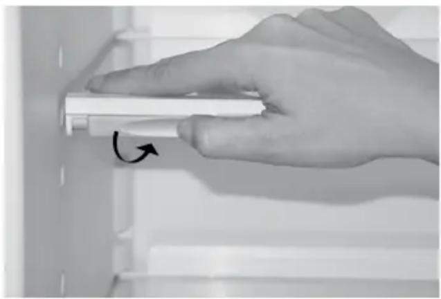 Hand holding a white cylindrical object with an arrow indicating rotation (no text or symbols visible)