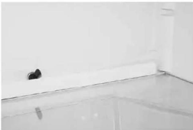 Interior wall with a white shelf and a small black object near the edge (no text or symbols visible)