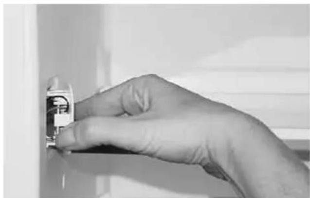 Close-up of a hand holding an electrical outlet terminal (no visible text or symbols)