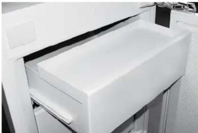 Close-up of a white plastic device with a rectangular lid, showing internal structure and no visible text or symbols.