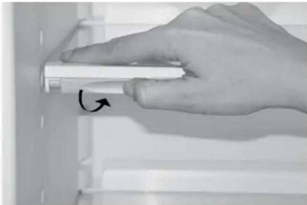 Hand holding a white cylindrical object with an arrow indicating rotation (no text or symbols visible)