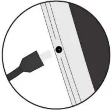Circular diagram showing a plug inserted into a device with a black dot and dashed lines indicating alignment (no text or symbols).