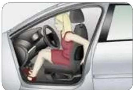 Interior view of a car showing a person seated in the driver's seat, with dashboard and steering wheel visible (no text or symbols)