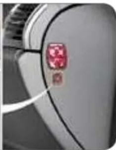 Close-up of a car's front panel with a red-lit button (no visible text or symbols)