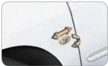 Close-up of a white car's side panel with two metallic arrows pointing to the front edge (no text or symbols visible)