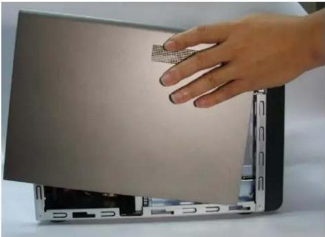Hand pressing down on a laptop keyboard, showing the screen and drive module (no text or symbols visible)
