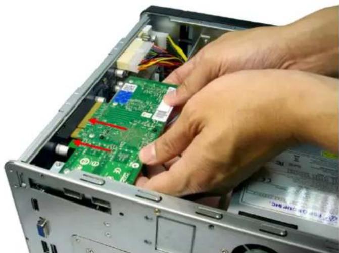 Close-up of hands installing or adjusting a green printed circuit board into a computer case (no visible text or symbols)