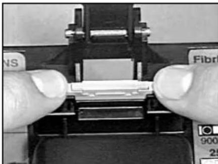 Close-up of hands adjusting a mechanical component with visible forceps and control buttons (no text or symbols)