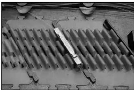 Close-up of a mechanical component with multiple grooves and a central rod (no visible text or symbols)