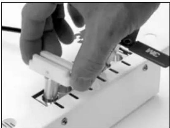 Close-up of a hand using a tool to adjust or install a mechanical component (no visible text or symbols)
