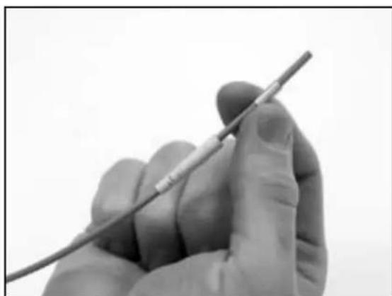Close-up of a gloved hand holding a pen, no visible text or symbols