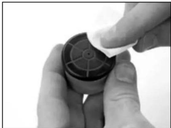 Close-up of hands holding a small black plastic container with a white cloth, no visible text or symbols