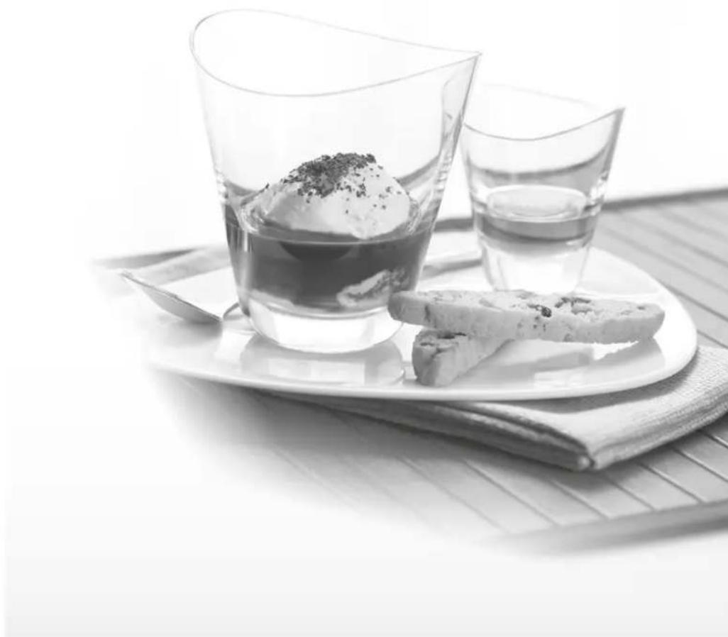 Black-and-white photo of two glasses on a tray with a spoon and a slice of food, no visible text or symbols.