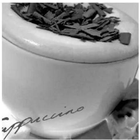 Close-up of a white ceramic cup with chocolate shavings, no visible text or symbols