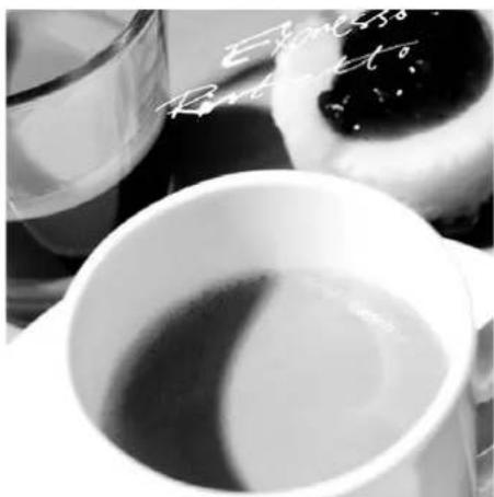 Black and white photo of a cup filled with tea, with a glass of milk and a spoon in the background (no visible text or symbols)