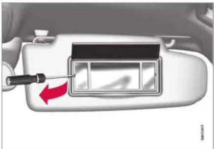 Close-up of a car interior with a screwdriver inserted, showing a red arrow pointing to a component (no text or symbols visible)