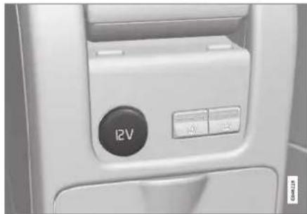 Close-up of a white office chair interior showing a black circular button labeled '12V' and control buttons (no readable text beyond basic symbols)