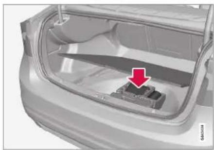 Exterior view of a car trunk with a highlighted component and red arrow indicating direction (no text or symbols)