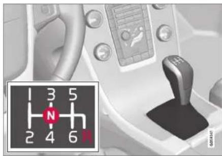 Close-up of a hand operating a vehicle gear shift lever with a numeric keypad and control panel (no visible text or symbols)