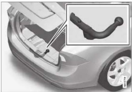 Close-up of a car's front wheel assembly with a close-up inset showing the handle (no text or symbols visible)