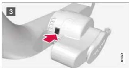 Close-up of a white mechanical component with a red arrow pointing to a small square feature (no text or symbols visible)