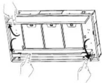 Diagram of hands holding a rectangular frame with internal compartments and arrows indicating rotation or movement (no text or symbols)