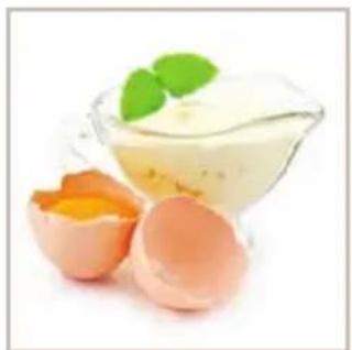 Close-up of cracked eggs and a glass bowl containing a creamy mixture, garnished with mint leaves (no text or symbols visible)