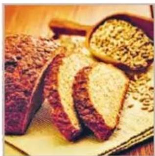 Close-up of sliced meat with sesame seeds on a wooden surface (no text or symbols visible)