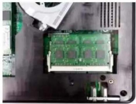 Close-up of a green CPU socket mounted on a motherboard, with a partially visible card partially inserted (no text or symbols)