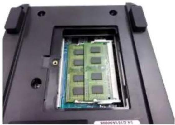 Close-up of a computer RAM module with visible internal circuitry and mounting holes (no text or symbols)