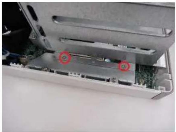 Interior view of a computer drive bay showing internal components and a circuit board (no visible text or symbols)