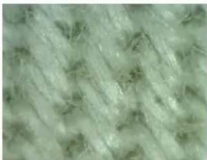 Close-up of a textured fabric with light green and beige fibers (no text or symbols).