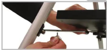 Close-up of hands installing a mechanical component with a small tool (no visible text or symbols)