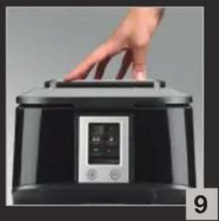 Hand placing a black microwave oven into a digital display (no visible text or symbols)