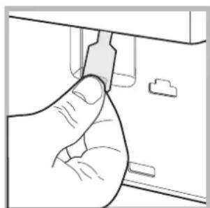 Line drawing of a hand inserting a component into a device (no text or symbols)