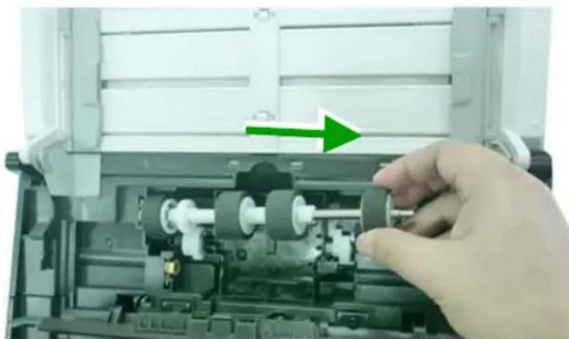 Close-up of a hand adjusting mechanical components in an open device (no visible text or symbols)