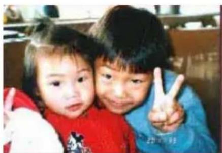 Two children making peace signs together (no visible text or symbols)