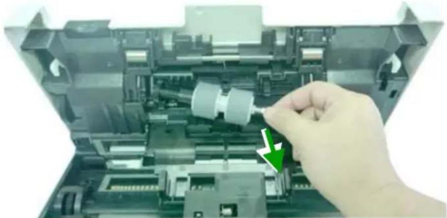 Close-up of a hand inserting a plastic component into an open electronic device casing (no visible text or symbols)