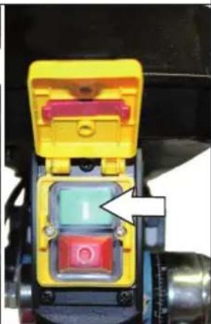 Close-up of a yellow and red mechanical component with a white arrow pointing to a green internal component (no text or symbols visible)