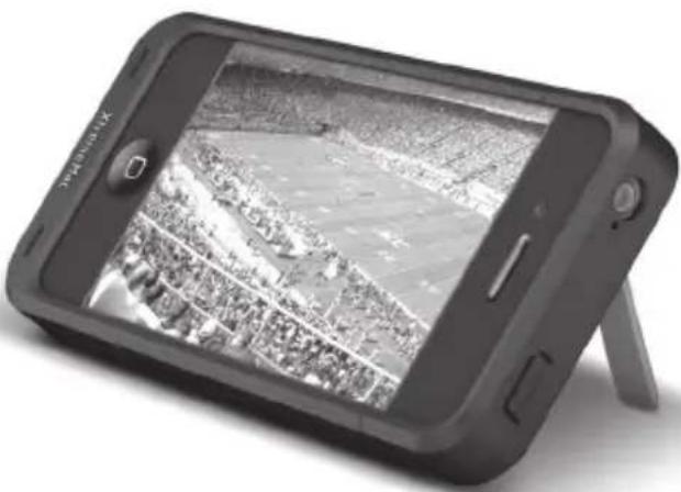 Black-and-white photo of a Samsung smartphone displaying a grayscale aerial view of a large outdoor arena with buildings and a crowd (no visible text or symbols)