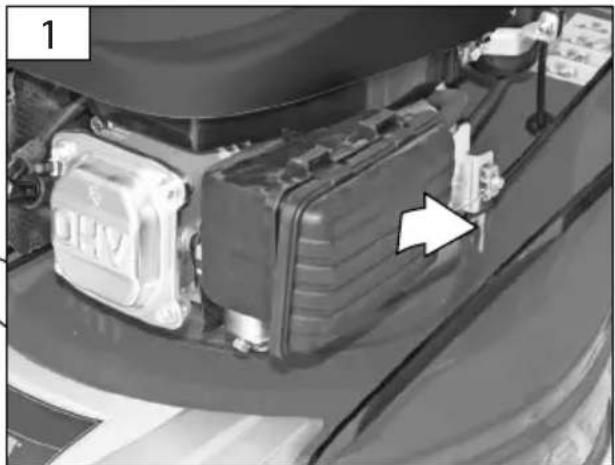 Close-up of a car engine bay with a black plastic housing and a white arrow pointing to a component (no visible text or symbols)