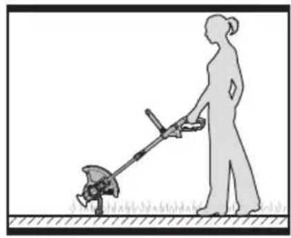 Silhouette of a person using a tool to cut a circular object on grass (no text or symbols)