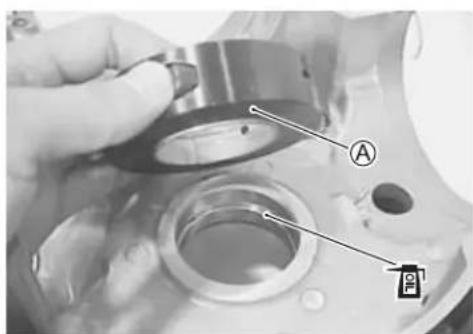 Close-up of a mechanical component with labeled parts A and B, showing a hand holding a circular component.