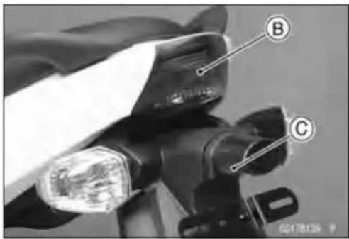 Close-up of a camera lens with labeled parts B and C, showing mechanical components and focal point