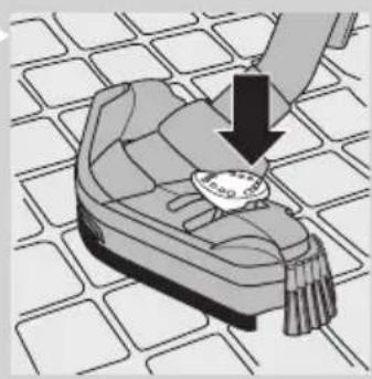 Illustration of a hand holding a small object over a patterned surface, with no visible text or symbols.