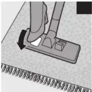 Close-up of a hand using a vacuum cleaner to press down a surface, showing foot and grip details (no text or symbols visible)